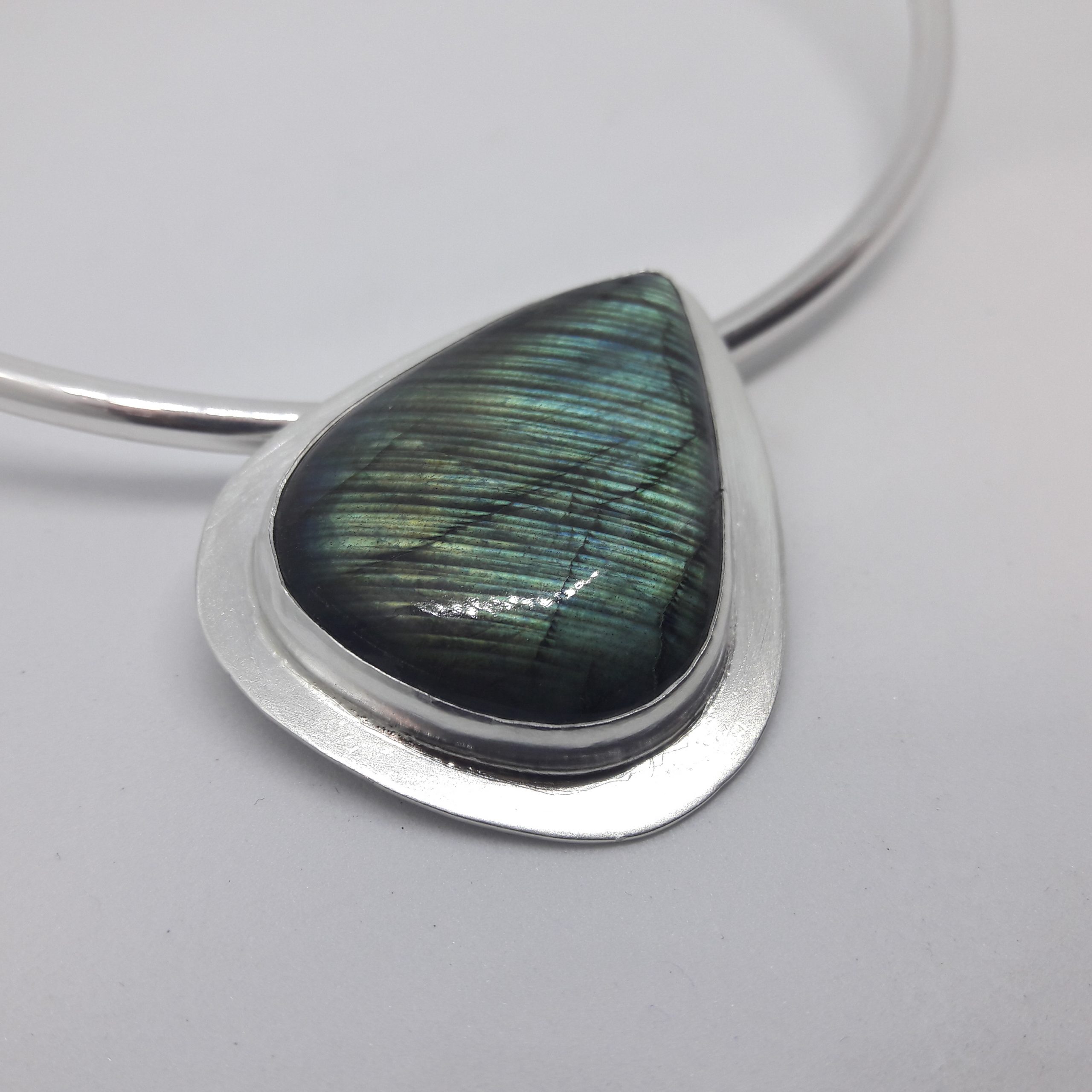 a silver pendant featuring a student's stone setting