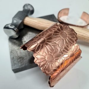 copper cuff with flower pattern and jewellery tools